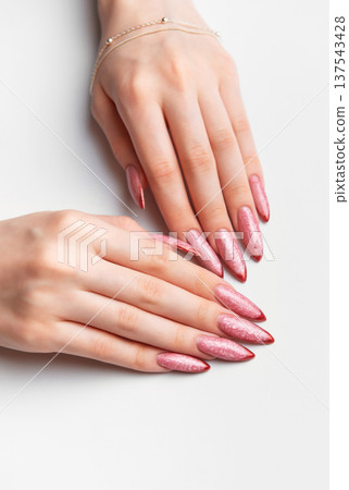 Woman hands manicure with long glittery rose gold nails Woman hands manicure with long glittery rose gold nails 137543428