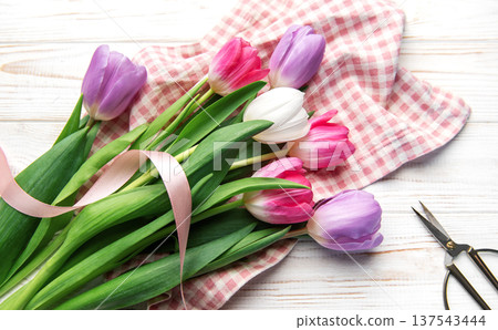 Colorful tulip bouquet with ribbon on white wooden background 137543444