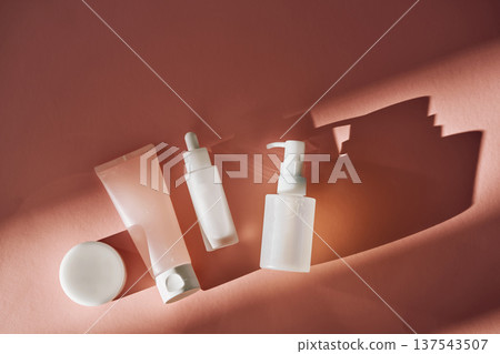 Skincare product bottles, tube, and jar on pink background Skincare product bottles, tube, and jar on pink background 137543507