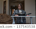 Smiling young boy looking at a covered frying pan on a small table. Child playing chef at home 137543538