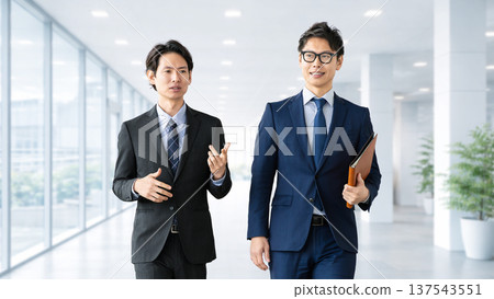 兩名男性商人邊走邊談 兩名男性商人邊走邊談 137543551