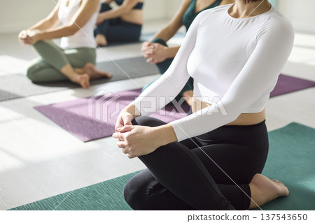 Close-up of women practicing yoga on mats during mindful group studio session Close-up of women practicing yoga on mats during mindful group studio session 137543650