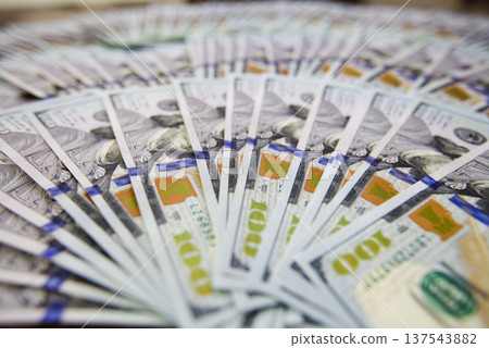 Hundred dollar bills spread in a fan shape on white background Hundred dollar bills spread in a fan shape on white background 137543882