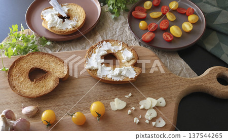 Round bruschetta with red and yellow cherry tomatoes and goat cheese on oak wooden board. Farm produce, crusty bread. Food and healthy eating. Round bruschetta with red and yellow cherry tomatoes and goat cheese on oak wooden board. Farm produce, crusty bread. Food and healthy eating. 137544265