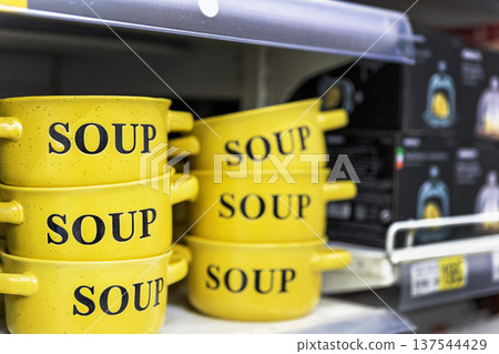 Yellow ceramic soup bowls stacked on a store shelf. Yellow ceramic soup bowls stacked on a store shelf. 137544429