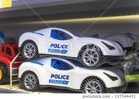 Toy police cars in protective mesh on a store shelf. Toy police cars in protective mesh on a store shelf. 137544431