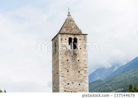 Historic bell tower in Riva del Garda, Italy, against a cloudy sky. 137544679