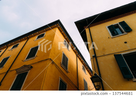 Buildings in Riva del Garda with yellow walls and dark shutters 137544681