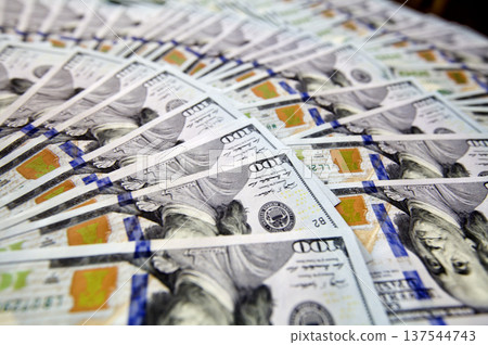Hundred dollar bills spread in a fan shape on white background 137544743