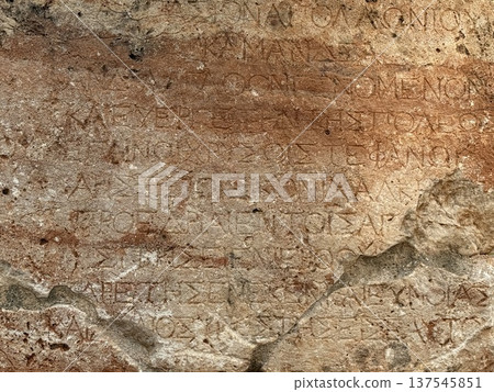 Ancient Greek inscription on weathered stone surface with lettering details and texture 137545851