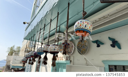 Colorful ceramic lanterns hanging on a shop facade in a coastal town setting Colorful ceramic lanterns hanging on a shop facade in a coastal town setting 137545853