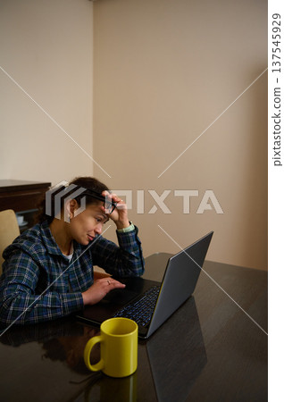 Woman Entrepreneur Working From Home On Laptop Looking Thoughtful With Coffee Mug Woman Entrepreneur Working From Home On Laptop Looking Thoughtful With Coffee Mug 137545929