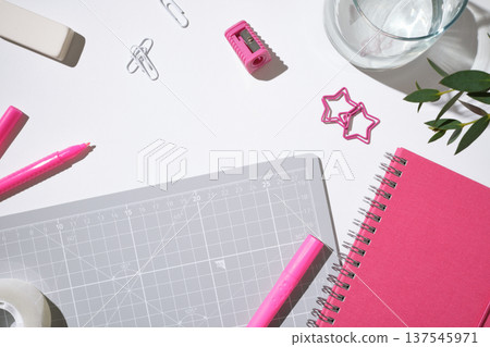 Workspace with pink sticky notes, pencils, tape, and clips on white table. Copyspace. Workspace with pink sticky notes, pencils, tape, and clips on white table. Copyspace. 137545971