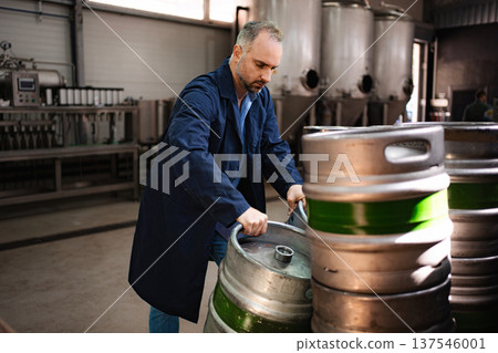 Man in coat carrying beer keg at brewery 137546001