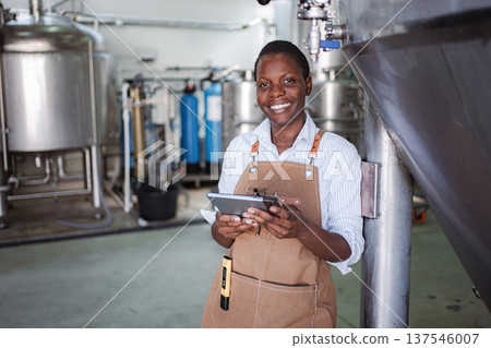 Female brewer managing production with digital tablet in brewery 137546007