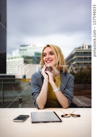 Happy businesswoman contemplating success in modern city environment 137546033