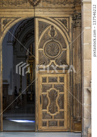 Beautiful wooden door frames the entrance to a stunning church in Malaga, Spain, inviting visitors to explore its exquisite architecture Beautiful wooden door frames the entrance to a stunning church in Malaga, Spain, inviting visitors to explore its exquisite architecture 137546212