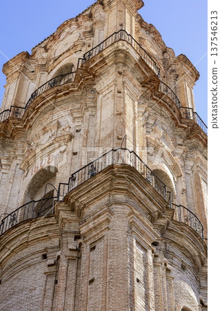 Historic bell tower rising proudly against a clear blue sky in Malaga, Spain, showcasing intricate architectural details and rustic charm 137546213