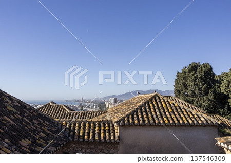 View of rooftops in Malaga, Spain from Alkazaba during clear day with coast and mountains in background View of rooftops in Malaga, Spain from Alkazaba during clear day with coast and mountains in background 137546309