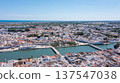 Tavira in Algarve is seen from above with traditional buildings lined along the Gilao river. The coastline and countryside can be observed in the distance 137547038