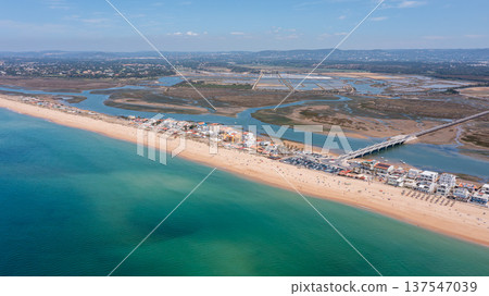 Praia de Faro along the coast in Ria Formosa, Algarve, Portugal, captured from above with clear water and land outlines on a sunny day 137547039