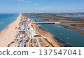 Aerial view captures Praia de Faro and Ria Formosa, displaying the beach, town, bridges, and water during a sunny day 137547041