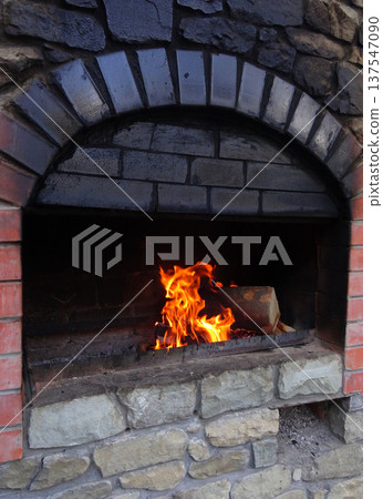 Fire Burns In A Sooted Brick Wood Stove Detailed  137547090