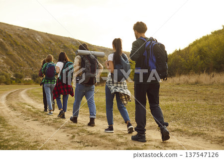 Tourist people walking rear, outdoor hiking travelling group going on countryside trail, footpath Tourist people walking rear, outdoor hiking travelling group going on countryside trail, footpath 137547126