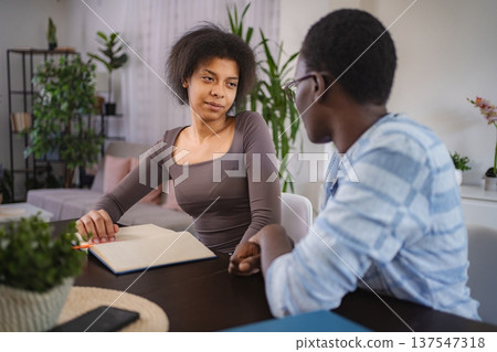 Young students studying together at home looking at each other 137547318