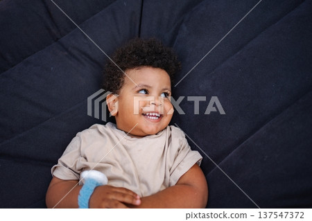 Happy toddler boy lying down smiling Happy toddler boy lying down smiling 137547372