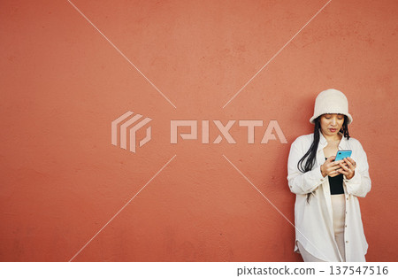 Wall, space and woman with phone in a city for travel, search or location on orange background. Smartphone, app and lady fashion influencer outdoor on social media, blog podcast or content creation Wall, space and woman with phone in a city for travel, search or location on orange background. Smartphone, app and lady fashion influencer outdoor on social media, blog podcast or content creation 137547516