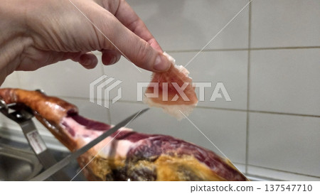 Slicing and serving traditional spanish ham for culinary delights Slicing and serving traditional spanish ham for culinary delights 137547710