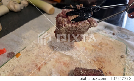 Preparing oxtail in flour coating for delicious home cooking. Traditional Spanish dish. Typical food of Spain Preparing oxtail in flour coating for delicious home cooking. Traditional Spanish dish. Typical food of Spain 137547730