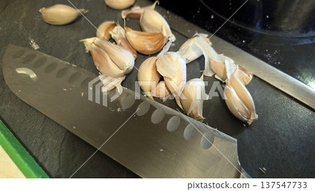 Oxtail preparation with fresh garlic and chef knife for culinary inspiration Oxtail preparation with fresh garlic and chef knife for culinary inspiration 137547733