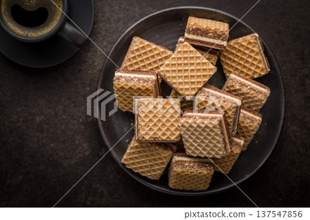 Stack of Chocolate Wafer Cookies on Plate with Coffee Cup and French Press 137547856