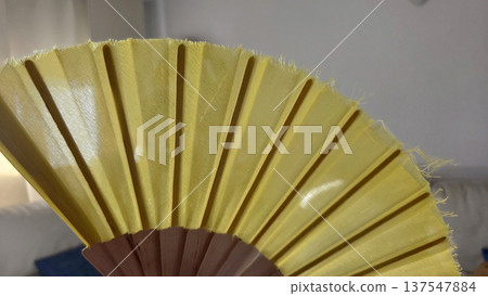 Elegant yellow hand fan for summer cooling and decorative use. Horizontal banner. Copy space Elegant yellow hand fan for summer cooling and decorative use. Horizontal banner. Copy space 137547884