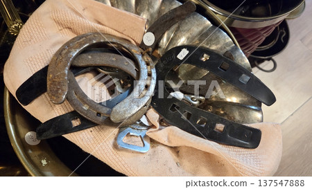 Vintage finds at an outdoor flea market displaying horseshoes and metal artifacts Vintage finds at an outdoor flea market displaying horseshoes and metal artifacts 137547888