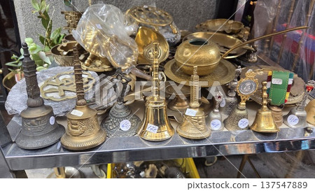 Antique bells and brassware display at a flea market for vintage collection and home decor. Rastro. Madrid. Spain 137547889