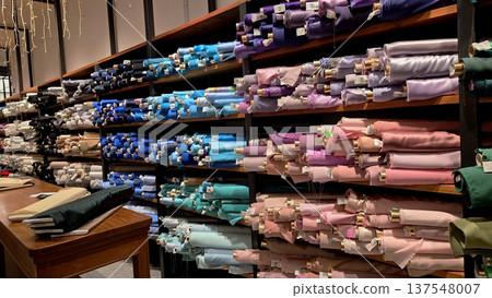 Colorful fabric rolls displayed in a textile store for sewing and craft projects 137548007