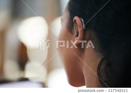 Hearing aid, closeup and deaf ear with sound and person with a disability for helping with audio and medical implant. Technology, patient and problem with listening support and wellness with back 137548321