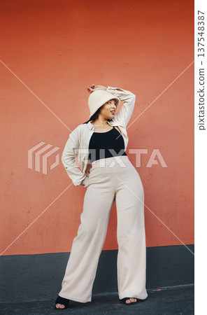 Woman, fashion and city wall with freedom, hipster style and urban clothes with confidence. Red background, traveling and stylish female person in town with cool and modern outfit and thinking Woman, fashion and city wall with freedom, hipster style and urban clothes with confidence. Red background, traveling and stylish female person in town with cool and modern outfit and thinking 137548387