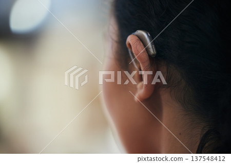 Hearing aid, closeup and ear with a person with a disability for helping with audio and medical implant. Technology, patient and healthcare problem with listening support and wellness tool with back Hearing aid, closeup and ear with a person with a disability for helping with audio and medical implant. Technology, patient and healthcare problem with listening support and wellness tool with back 137548412