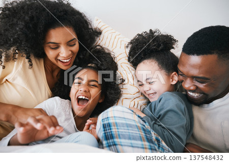 Mom, dad and children in bed with tickling, comic joke and laugh with bonding, care and love in family home. Black man, mother and daughter with smile, play game or crazy in bedroom, morning or house 137548432