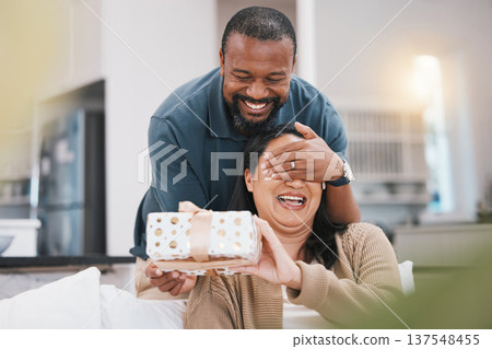 Birthday gift surprise, cover eyes and couple smile, woman and black man giving package for love, anniversary or gratitude. Living room couch, marriage and home people happy for present box 137548455