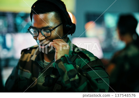 Control room man, surveillance and military communication, army risk dispatch or security telecom advice. Headset, 911 emergency consultation and African soldier consulting on intel support service Control room man, surveillance and military communication, army risk dispatch or security telecom advice. Headset, 911 emergency consultation and African soldier consulting on intel support service 137548576