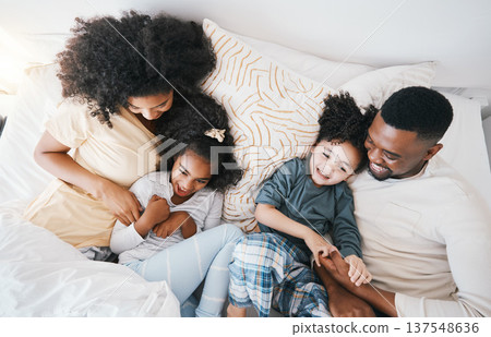 Mom, father and kids in bed with tickling, comic joke and laugh in top view, care and love in family house. Black man, mother and daughter with smile, play game and crazy in bedroom, morning and home 137548636