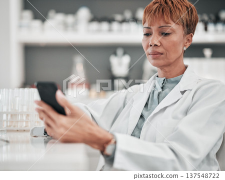 Woman, medical science and a phone in a laboratory for online communication, email or website. Mature scientist person with smartphone typing medicine research, results or network database app 137548722