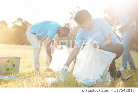 Nature recycling, community service volunteer and woman cleaning garbage, grass field trash or plastic pollution. Earth Day cooperation, eco project and charity team help with product clean up 137548815