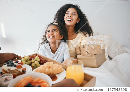 Breakfast, mothers day and child with mom in bed to relax for eating healthy, nutrition and diet. Happy, smile and young woman with girl kid in bedroom with gifts, presents and food at family home. Breakfast, mothers day and child with mom in bed to relax for eating healthy, nutrition and diet. Happy, smile and young woman with girl kid in bedroom with gifts, presents and food at family home. 137548898