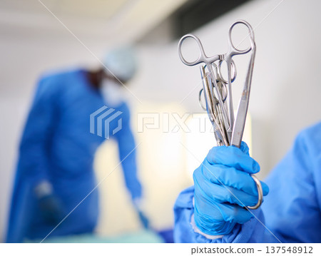Hand, scissors and a doctor in a hospital or theatre to start operation with surgical tools. Zoom on a surgeon, assistant or staff with sterile equipment for medical procedure or emergency healthcare 137548912